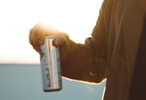 person holding RedBull labeled can during daytime